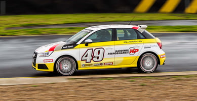 A yellow and white Audi Quattro racing car sponsored by Harding Performance